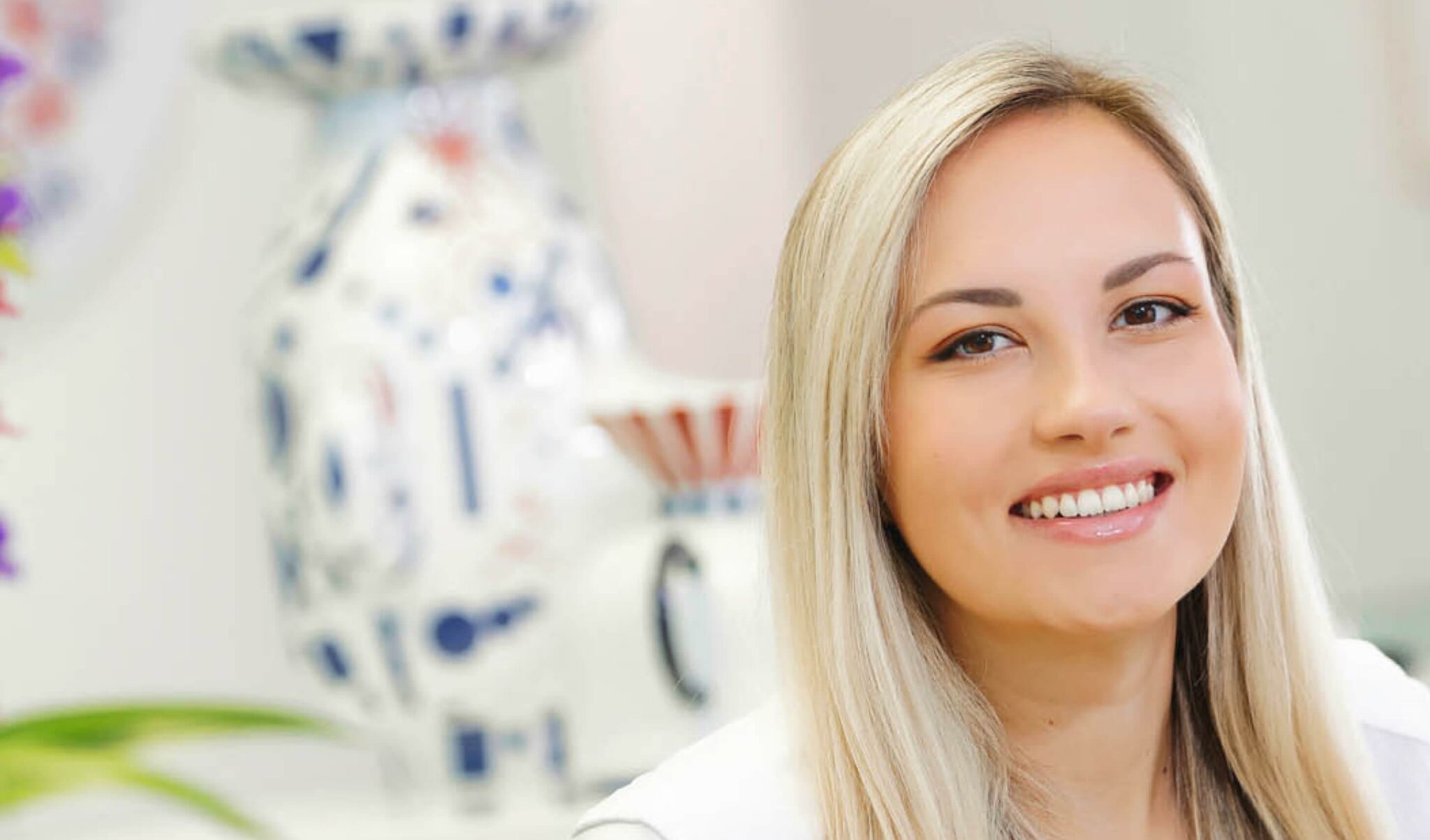 Freundliche Rezeptionistin lächelt in der Praxis Dr. Horvath