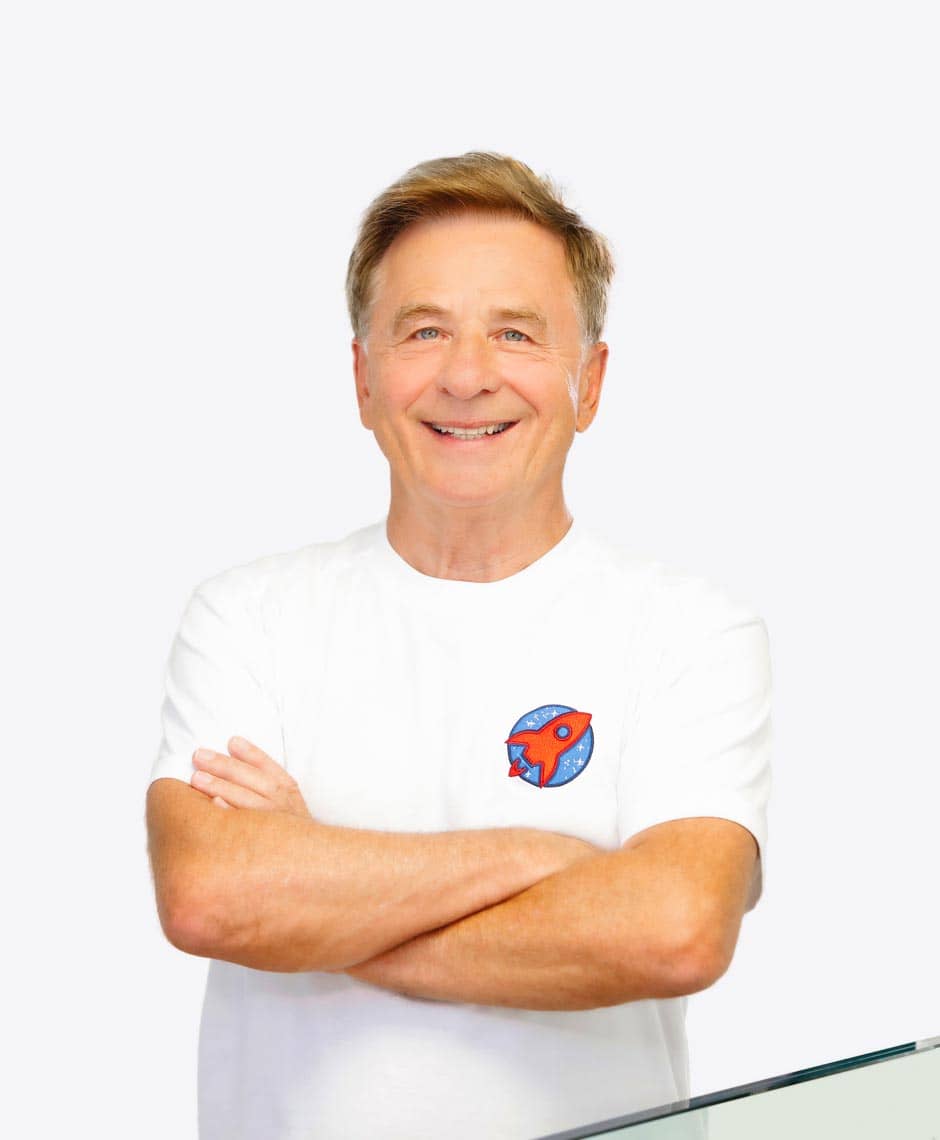 Porträt von Dr. Domonkos Horváth, einem erfahrenen Zahnarzt, der mit verschränkten Armen lächelnd in seiner Praxis steht, was Vertrauen und Professionalität ausstrahlt.