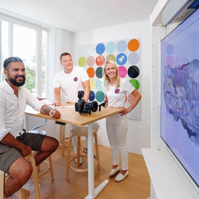 Innovative Patientenberatung bei Dr. Horvath: Ein Bild der Zahnärzte Dr. Nicole und Dr. Sebastian Horvath im Gespräch mit einem Patienten. Die moderne Praxisumgebung mit digitalem Display und die Verwendung von visuellen Hilfsmitteln zur Patientenaufklärung demonstrieren das Engagement der Praxis für fortschrittliche Zahnmedizin und Patientenbetreuung