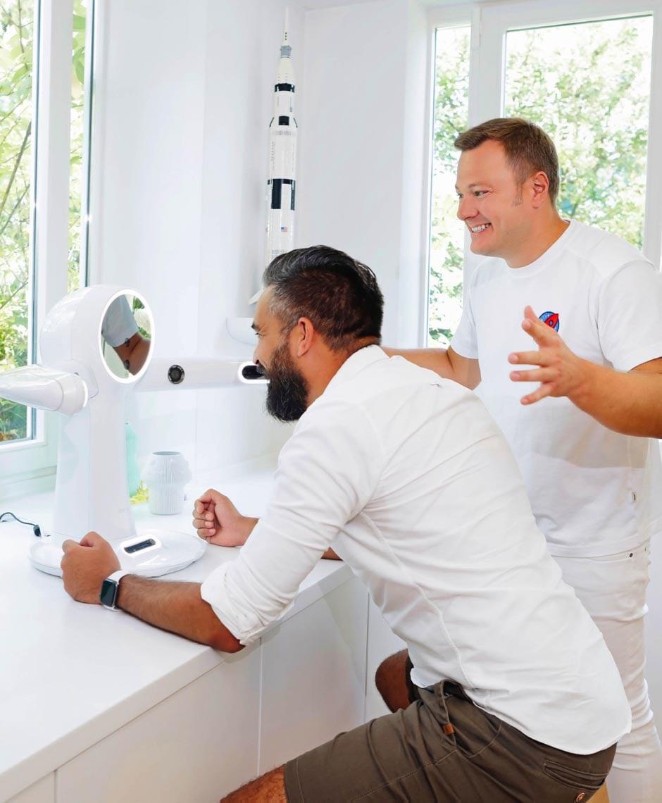 Zukunftsorientierte Zahnmedizin: Dr. Sebastian Horvath demonstriert einem Patienten die neueste 3D-Gesichtsscanning-Technologie zur genauen Planung zahnmedizinischer Behandlungen. Dieses Bild fängt die innovative Technik ein, die für präzise und individuelle Ergebnisse sorgt.