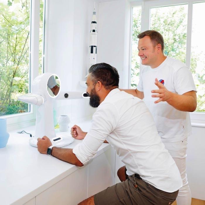 Zukunftsorientierte Zahnmedizin: Dr. Sebastian Horvath demonstriert einem Patienten die neueste 3D-Gesichtsscanning-Technologie zur genauen Planung zahnmedizinischer Behandlungen. Dieses Bild fängt die innovative Technik ein, die für präzise und individuelle Ergebnisse sorgt.