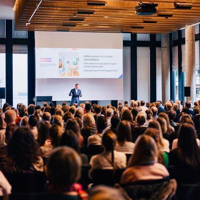 Dr. Sebastian Horvath hält einen fesselnden Vortrag über moderne Zahnmedizin vor einem interessierten Publikum. Die Zuhörer folgen gespannt den innovativen Behandlungsmethoden und neuesten Technologien für ästhetische Korrekturen.