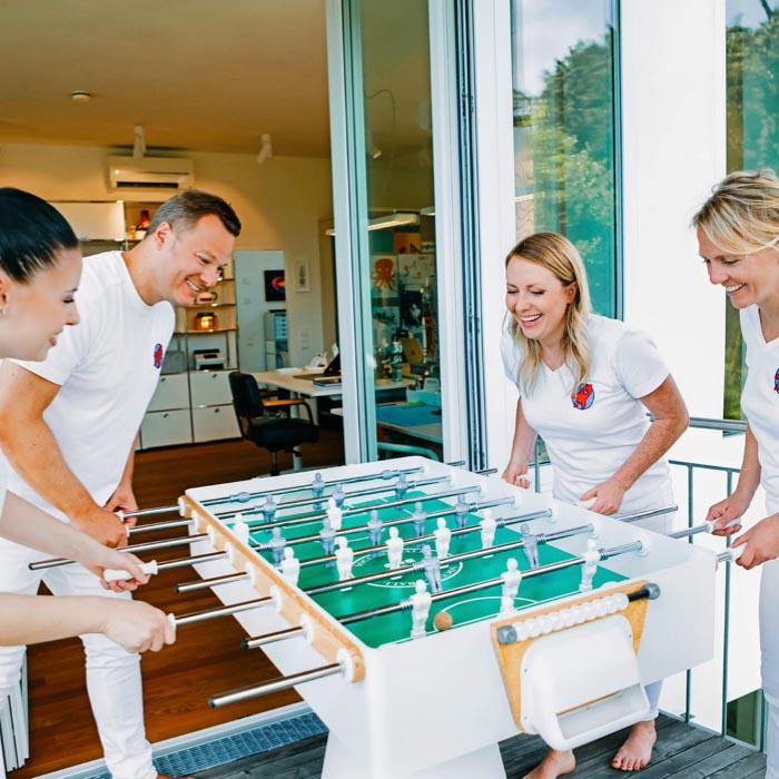Einblick in die entspannte Atmosphäre der Zahnarztpraxis Dr. Horvath in Jestetten bei Zürich – das Team beim Tischfußball im Pausenraum.