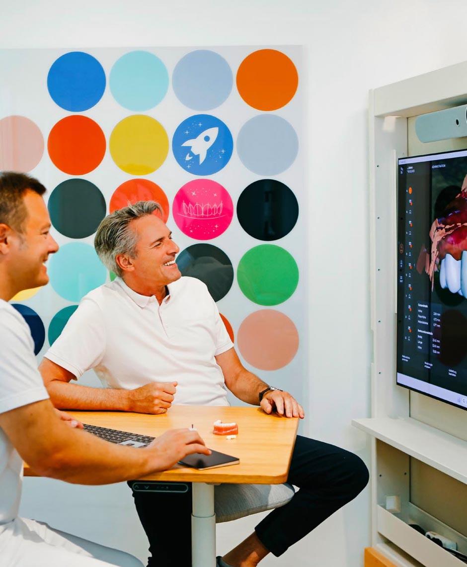 Digitale Visualisierung der geplanten Zahnbehandlung auf großem Bildschirm mit Dr. Sebastian Horvath, Spezialist für Veneers und Zahnsanierung.