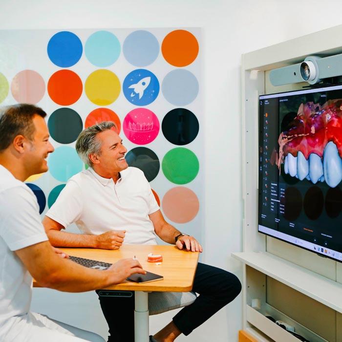 Digitale Visualisierung der geplanten Zahnbehandlung auf großem Bildschirm mit Dr. Sebastian Horvath, Spezialist für Veneers und Zahnsanierung.
