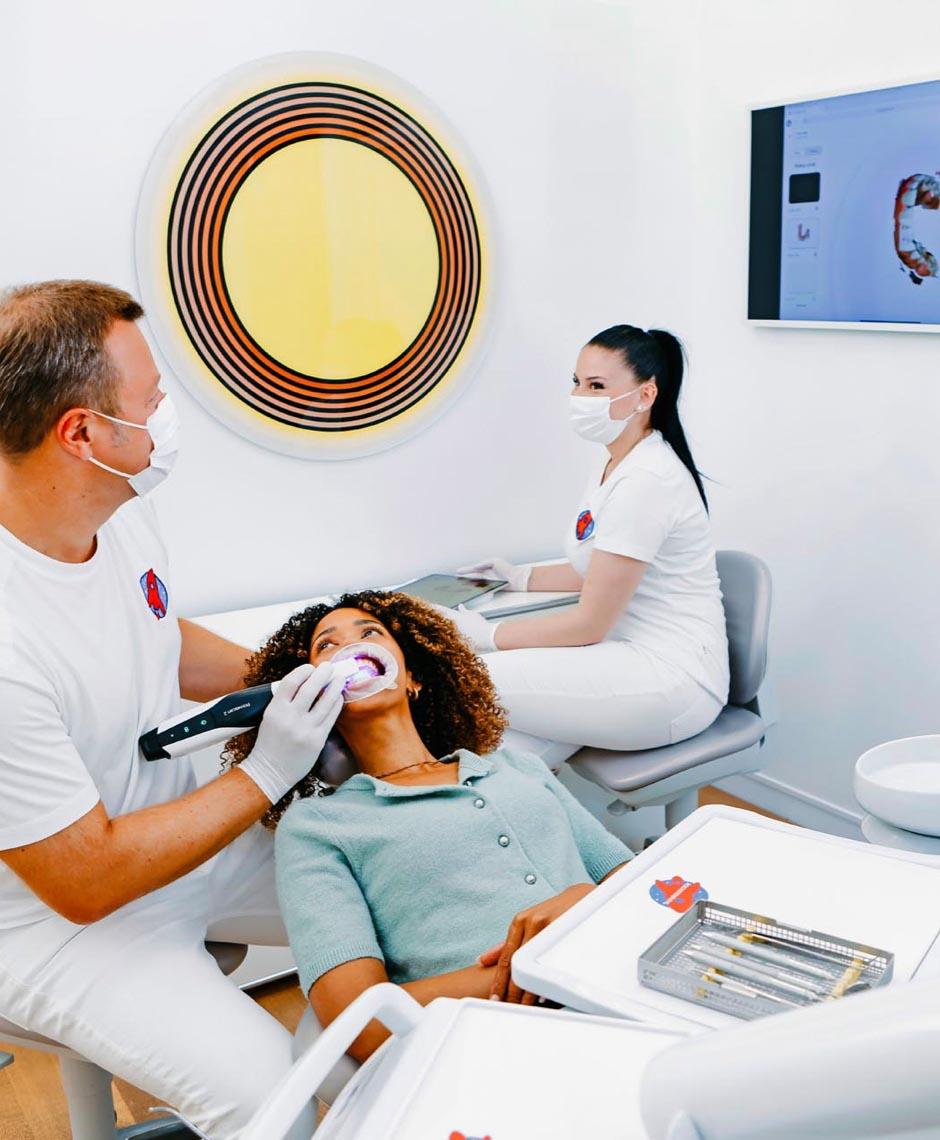 Dr. Sebastian Horvath scannt Zähne einer Patientin mit Intraoralscanner in der Zahnarztpraxis Jestetten – Spezialist für Zahnkronen, Implantate und Veneers.
