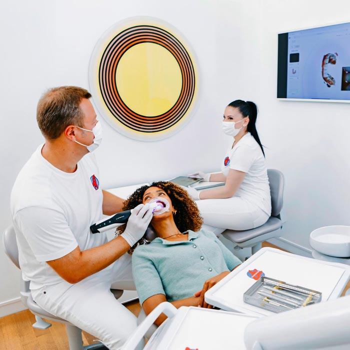 Dr. Sebastian Horvath scannt Zähne einer Patientin mit Intraoralscanner in der Zahnarztpraxis Jestetten – Spezialist für Zahnkronen, Implantate und Veneers.