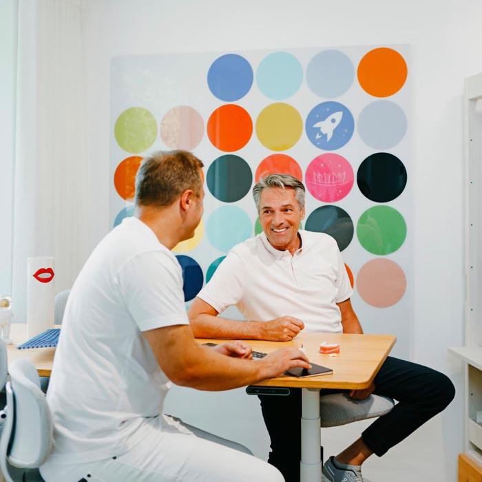Dr. Sebastian Horvath erklärt einem Patienten die Möglichkeiten der Zahnsanierung und des Zahnersatzes in der modernen Praxis in Jestetten nahe Zürich.