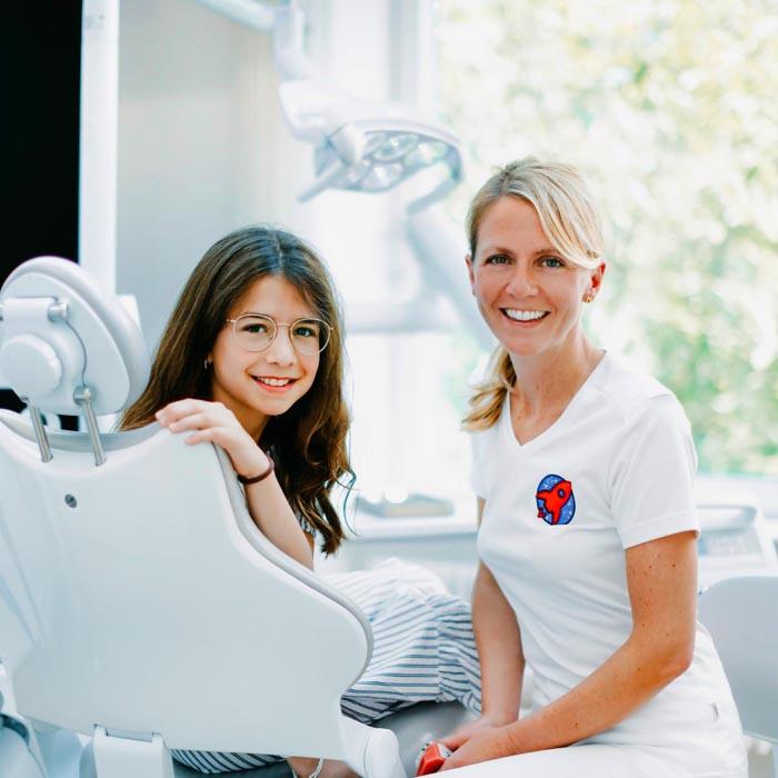 Dr. Nicole Horvath mit junger Patientin im Behandlungsstuhl – kinderfreundliche Kieferorthopädie in Jestetten bei Zürich, spezialisiert auf Kieferorthopädie.