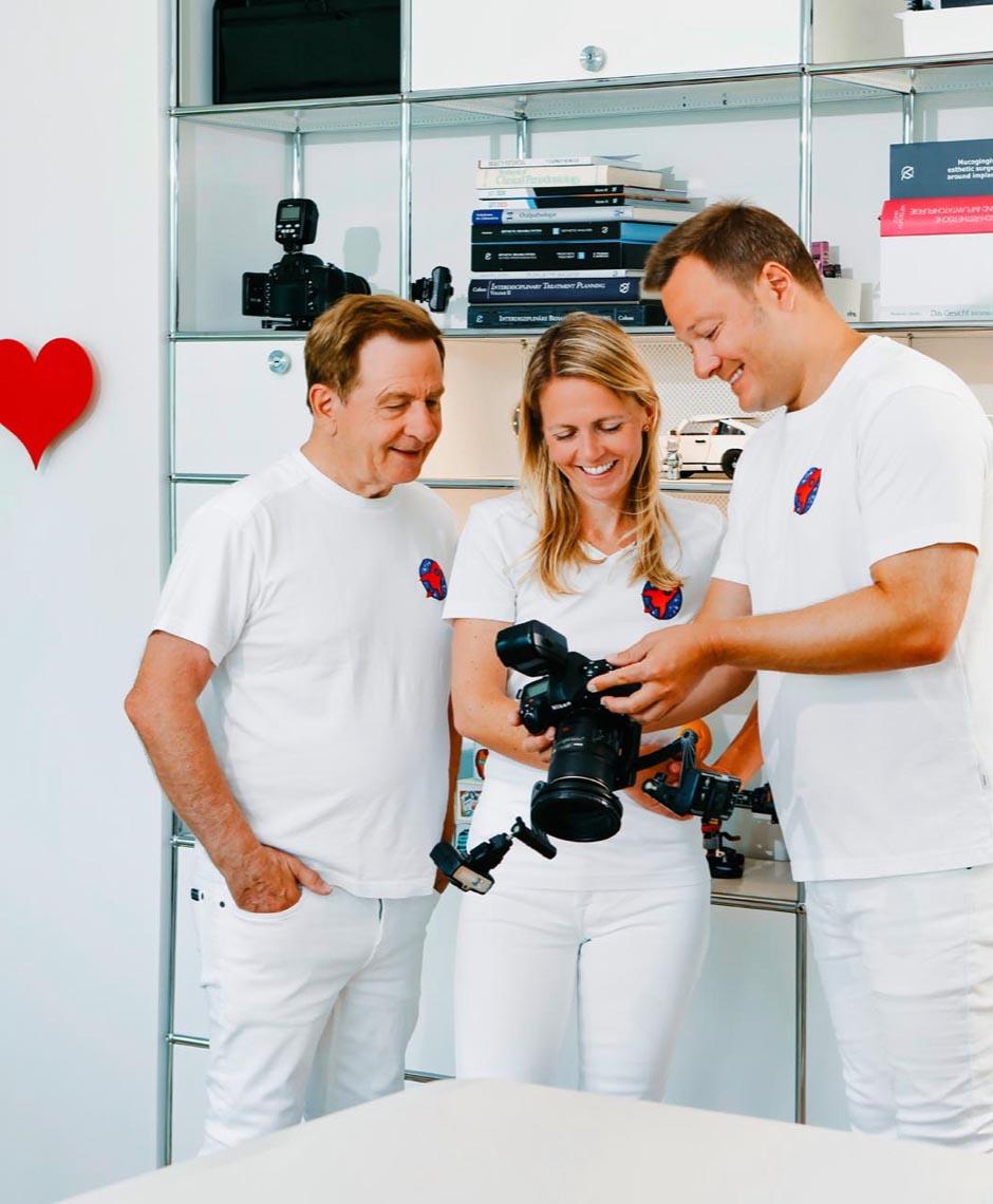 Dr. Horvath senior, Dr. Nicole Horvath und Dr. Sebastian Horvath besprechen Fotomaterial in der Zahnarztpraxis Jestetten, nahe Zürich – Invisalign, Kieferorthopädie und Zahnsanierung.