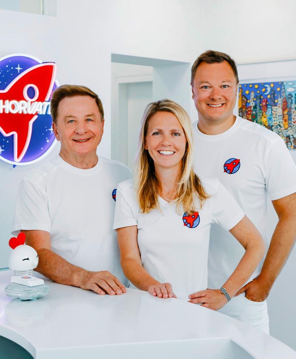 Dr. Nicole Horvath, Dr. Sebastian Horvath und Dr. Horvath senior im Empfangsbereich der Zahnarztpraxis Jestetten bei Zürich – Experten für Kieferorthopädie, Invisalign, Veneers und Zahnimplantate.